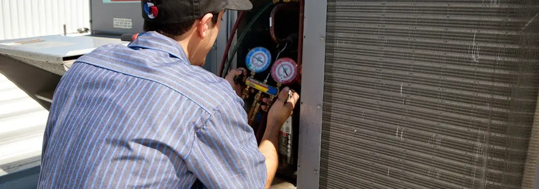 HVAC technician servicing a condenser unit in Florence