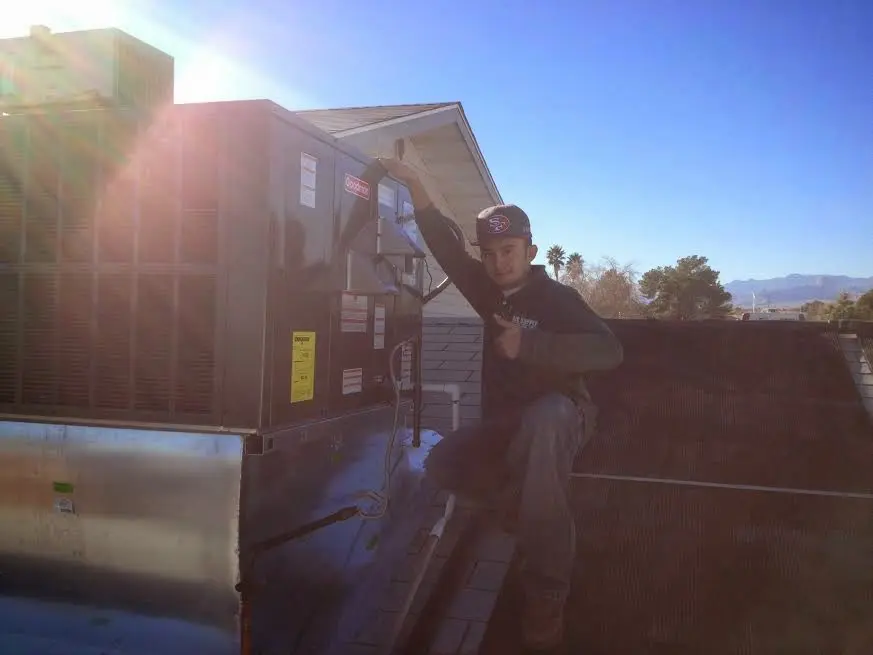 HVAC technician performing HVAC Inspection on a rooftop unit in Florence